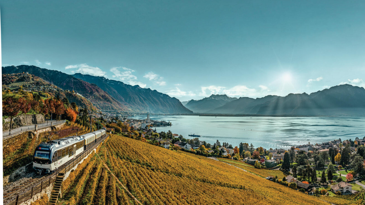 GoldenPass-trein rijdt door de wijngaarden van Lavaux met uitzicht op het Meer van Genève en de Alpen.