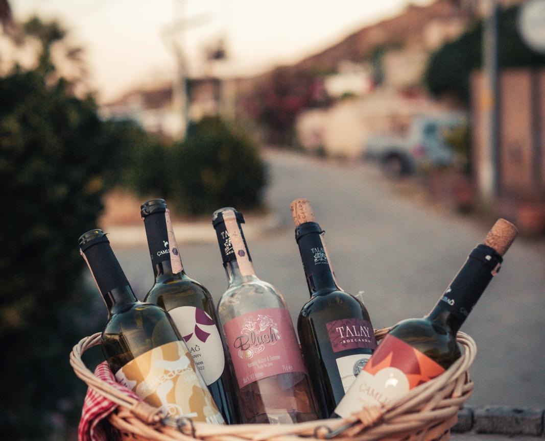 Mand met lokale wijnflessen uit Bozcaada, een eiland in Turkije met eeuwenoude wijntraditie