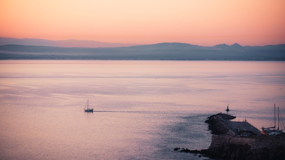 Zeilboot en havenpier tijdens zonsondergang bij Bozcaada, een eiland voor de kust van Turkije