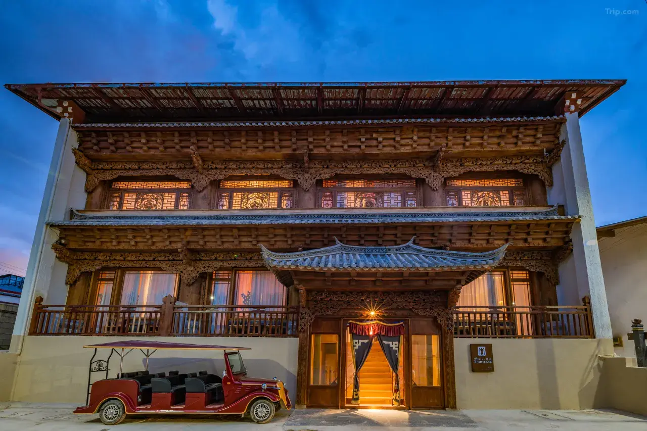 Tibetaans guesthouse Khimtsang Inn in Shangri-La, China, met houten gevel en rijk houtsnijwerk bij schemering