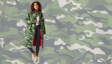 Vrouw draagt lange camouflagejas met roze voering voor reisliefhebbers die droog én stijlvol willen blijven
