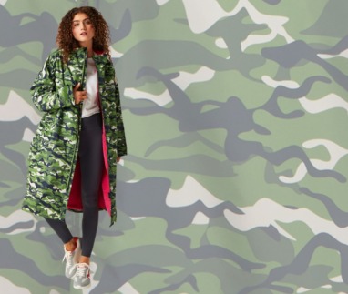 Vrouw draagt lange camouflagejas met roze voering voor reisliefhebbers die droog én stijlvol willen blijven