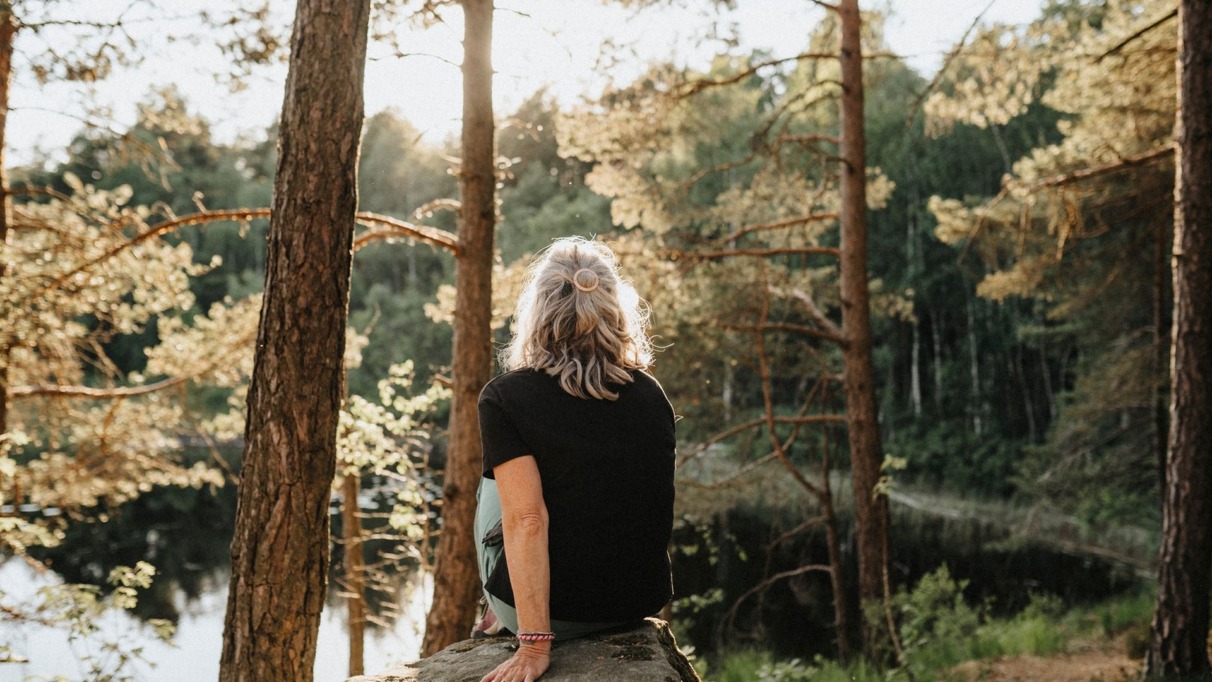 Vrouw kijkt uit over een meer in Zweden
