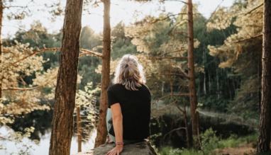 Vrouw kijkt uit over een meer in Zweden