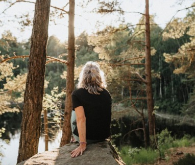 Vrouw kijkt uit over een meer in Zweden