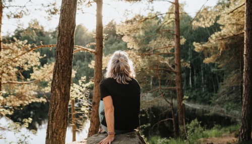 Vrouw kijkt uit over een meer in Zweden