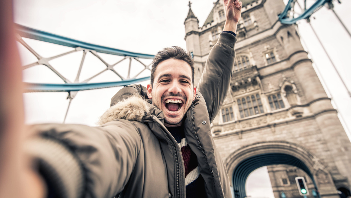 Man staat vrolijk op de Towerbridge in Londen. De stad is verkozen tot beste wereldstad van 2026.