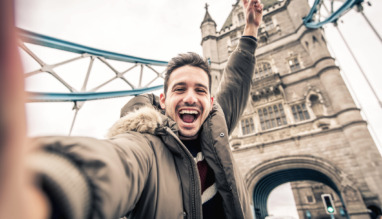 Man staat vrolijk op de Towerbridge in Londen. De stad is verkozen tot beste wereldstad van 2026.