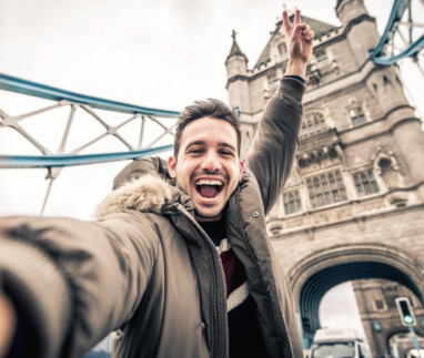 Man staat vrolijk op de Towerbridge in Londen. De stad is verkozen tot beste wereldstad van 2026.