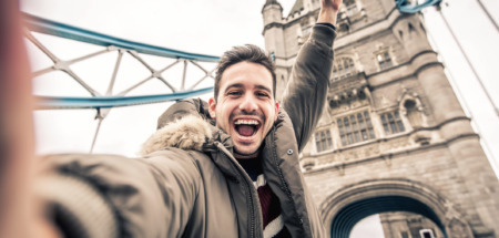 Man staat vrolijk op de Towerbridge in Londen. De stad is verkozen tot beste wereldstad van 2026.