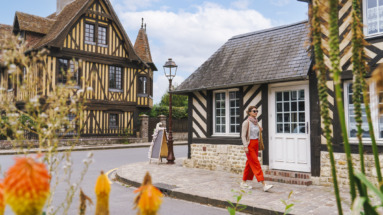Vrouw wandelt door Beuvron-en-Auge in Normandië, Frankrijk
