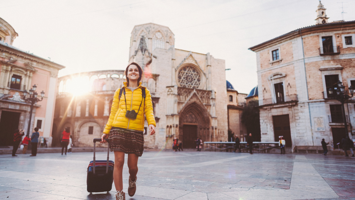 Meisje loopt in de winter met koffer door Valencia, Spanje