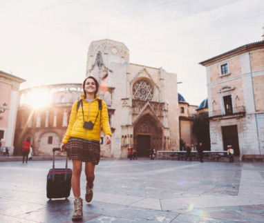 Meisje loopt in de winter met koffer door Valencia, Spanje