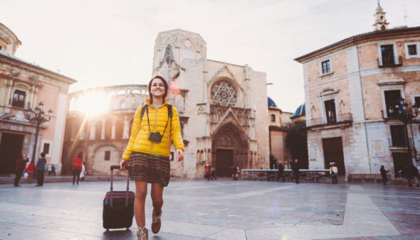 Meisje loopt in de winter met koffer door Valencia, Spanje