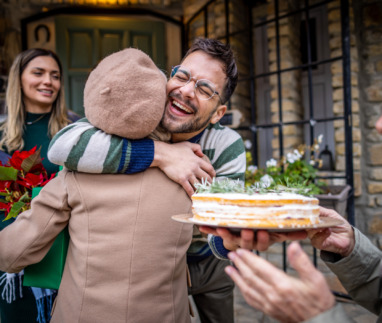 Jonge man knuffelt gasten met geschenken