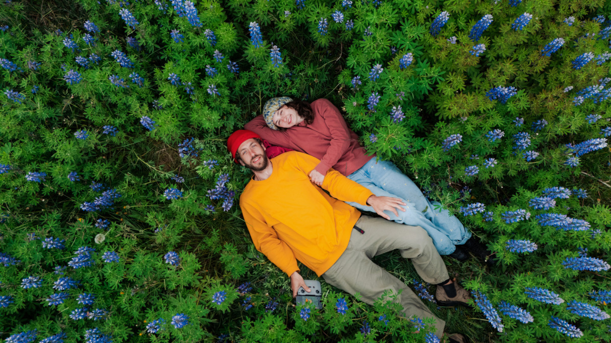 Man en vrouw liggen tussen de bloemen in IJsland, het vreedzaamste land ter wereld in 2026