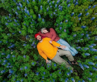 Man en vrouw liggen tussen de bloemen in IJsland, het vreedzaamste land ter wereld in 2026
