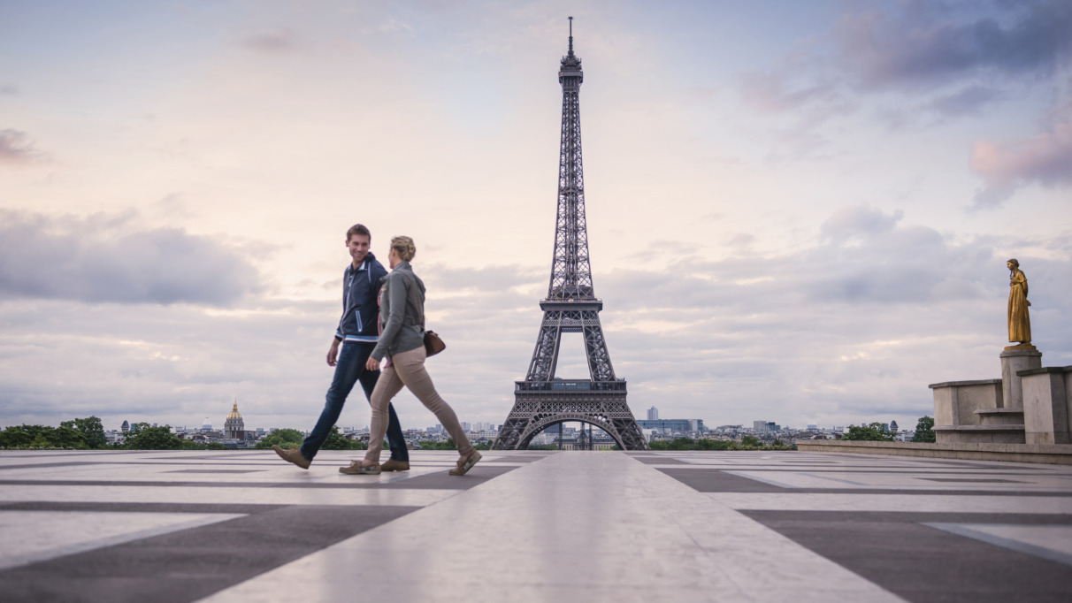 Stel loopt voor de Eiffeltoren in Parijs langs