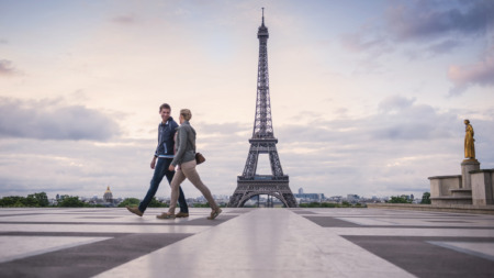 Stel loopt voor de Eiffeltoren in Parijs langs