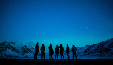 Een groep mensen kijkt naar het noorderlicht in Zuid-Ijsland