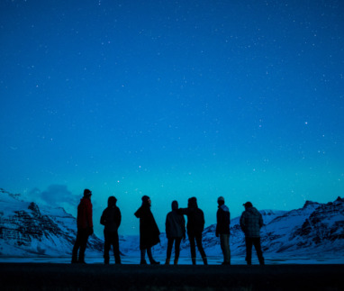 Een groep mensen kijkt naar het noorderlicht in Zuid-Ijsland