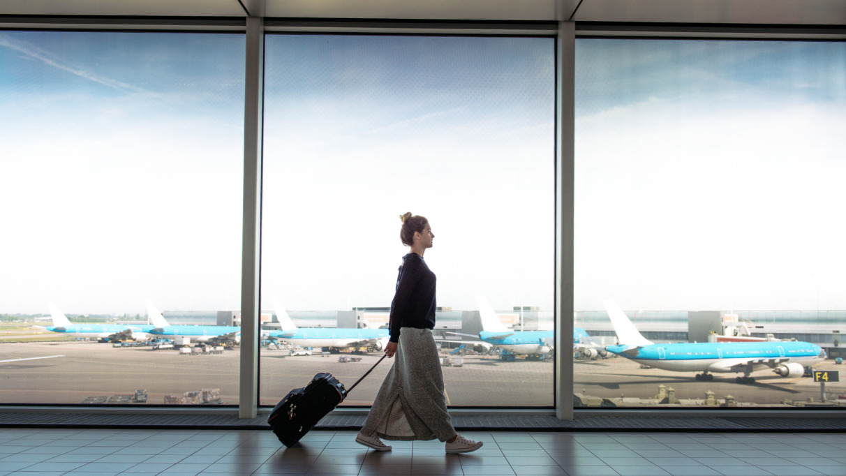 Woman with suitcase is going to board on the next flight