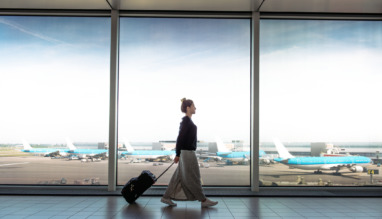 Woman with suitcase is going to board on the next flight