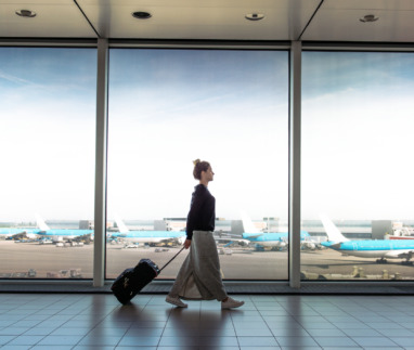 Woman with suitcase is going to board on the next flight