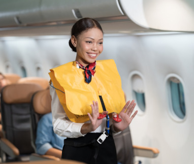 Stewardess toont veiligheidsinstructies aan boord van vliegtuig