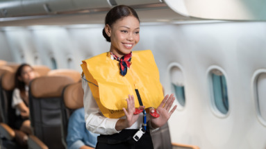 Stewardess toont veiligheidsinstructies aan boord van vliegtuig