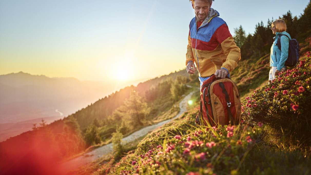 Twee hikers kijken in de lente uit over de bergen van Tirol
