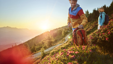 Twee hikers kijken in de lente uit over de bergen van Tirol