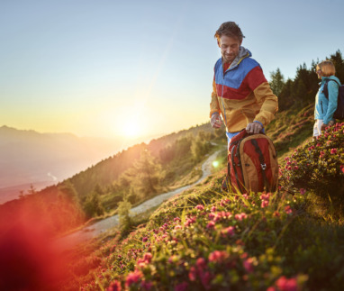 Twee hikers kijken in de lente uit over de bergen van Tirol