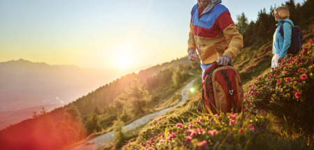 Twee hikers kijken in de lente uit over de bergen van Tirol