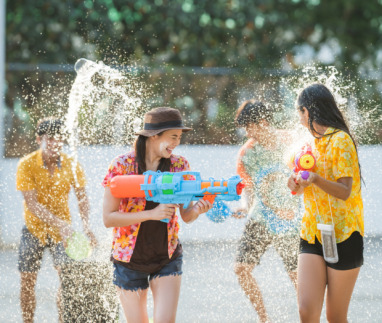 Thaise jongeren gebruiken waterpistolen om elkaar nat te spuiten tijdens Songkran