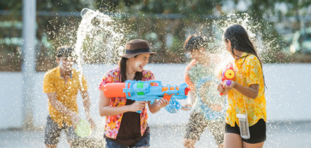 Thaise jongeren gebruiken waterpistolen om elkaar nat te spuiten tijdens Songkran