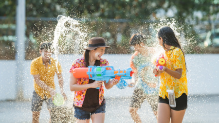 Thaise jongeren gebruiken waterpistolen om elkaar nat te spuiten tijdens Songkran