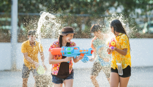 Thaise jongeren gebruiken waterpistolen om elkaar nat te spuiten tijdens Songkran