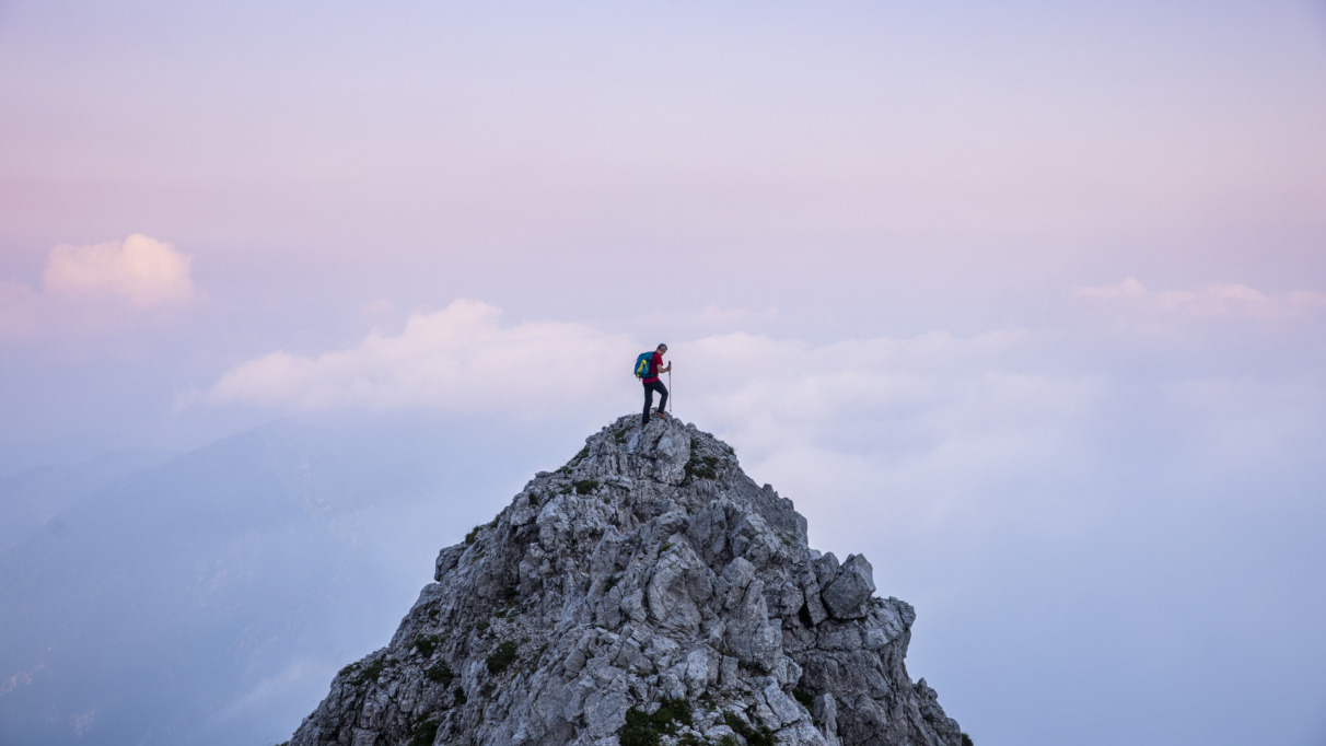 hiker op bergtop tijdens zosondergang