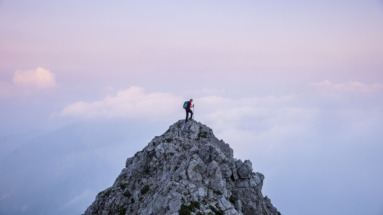 hiker op bergtop tijdens zosondergang