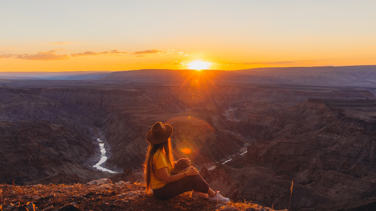 jonge vrouw geniet van zonsondergang over de fish river canyon