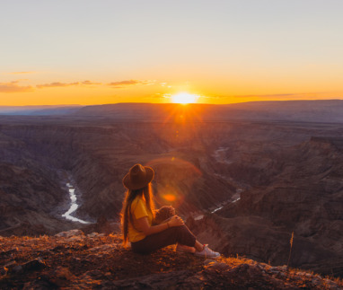 jonge vrouw geniet van zonsondergang over de fish river canyon