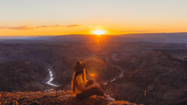 jonge vrouw geniet van zonsondergang over de fish river canyon