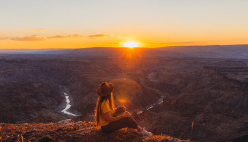 jonge vrouw geniet van zonsondergang over de fish river canyon