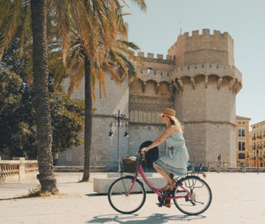 Vrouw fietst langs de Torres de Serranos-poort in Valencia, Spanje