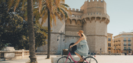 Vrouw fietst langs de Torres de Serranos-poort in Valencia, Spanje