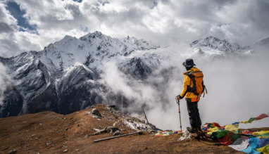 Trekker staat in Nepal en kijkt uit over Himalaya