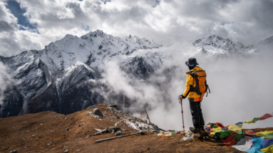 Trekker staat in Nepal en kijkt uit over Himalaya