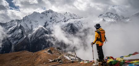 Trekker staat in Nepal en kijkt uit over Himalaya