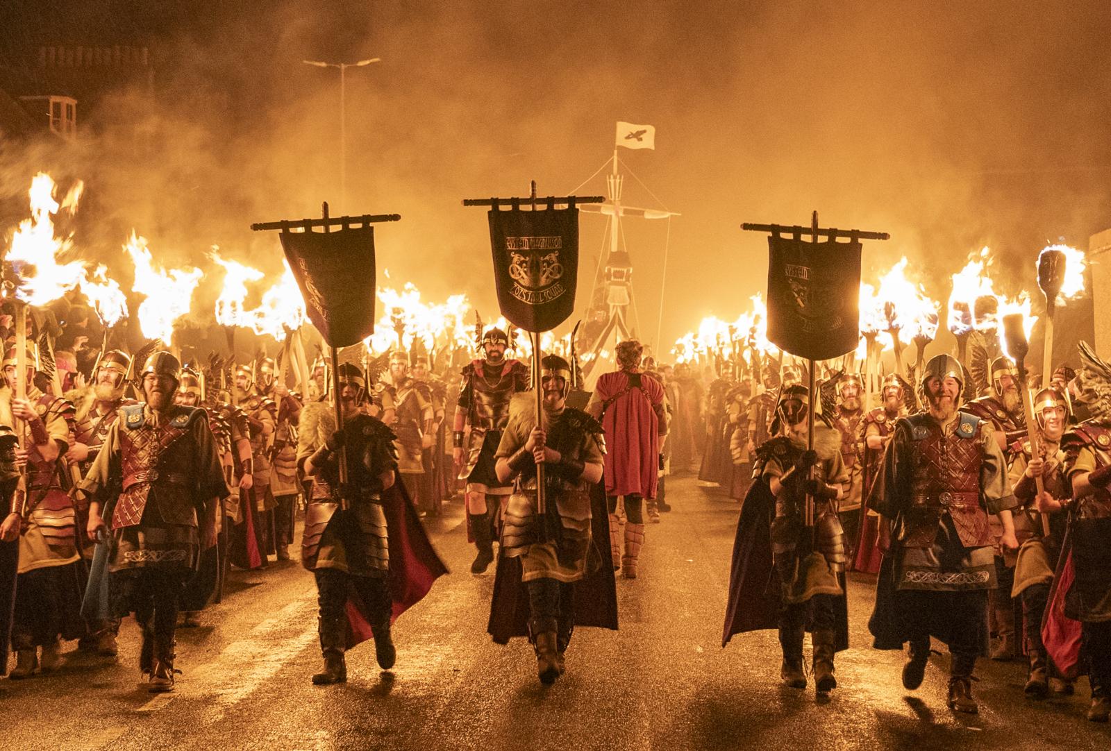 Vikingen in historische kledij lopen met fakkels tijdens het Up Helly Aa-festival op de Shetlandeilanden.